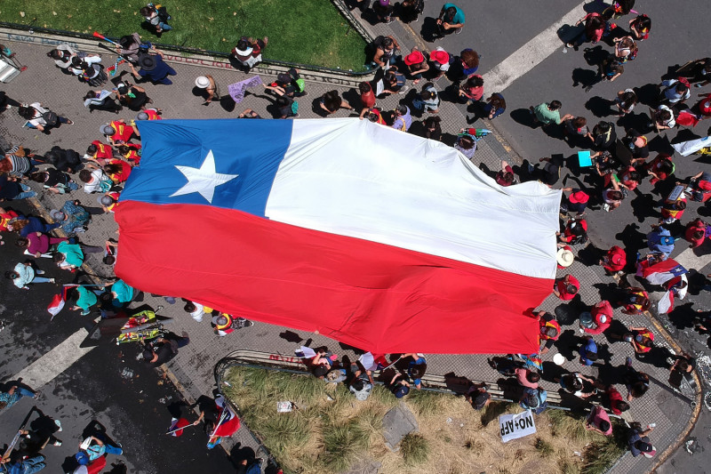 SANTIAGO%2C+CHILE+-+NOVEMBER+12%3A+Aerial+view+as+demonstrators+march+through+La+Alameda%2C+main+avenue+of+Santiago%2C+during+a+national+strike+and+general+demonstration+called+by+different+workers+unions+on+November+12%2C+2019+in+Santiago%2C+Chile.+Call+was+made+by+the+National+Strike+Committee+which+gathers+workers+of+different+industries+including+port%2C+mining%2C+construction%2C+industry%2C+trade%2C+education%2C+health+care%2C+agriculture+and+public+services+sectors.+On+Sunday%2C+Government+announced+it+has+agreed+to+start+the+process+to+write+a+new+Constitution+for+the+country%2C+which+is+one+of+the+most+repeated+demands+by+the+demonstrators+since+October+18.+Social+unrest+continues+since+a+raise+in+subway+fare+triggered+more+demands+related+to+health+care%2C+pension+system%2C+public+education%2C+social+mobility%2C+privatization+of+water+services+and+corruption.++%28Photo+by+Marcelo+Hernandez%2FGetty+Images%29